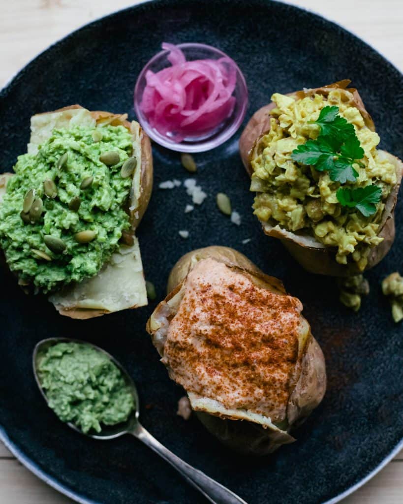 Three baked potatoes on a plate